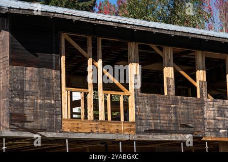 Umfangreiche Renovierung und Renovierung eines alten Holzgebäudes, ausgehöhlt bis zu den Außenwänden und Balken, Baustelle an einem sonnigen Herbsttag Stockfoto
