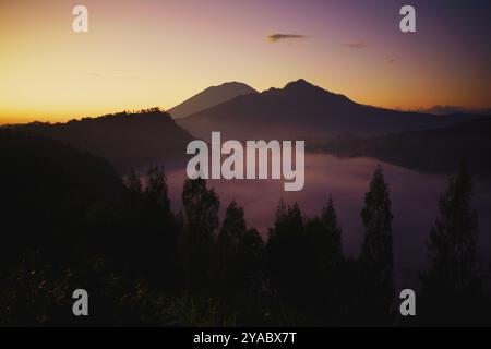 Erleben Sie den majestätischen Sonnenaufgang über den Berggipfeln und Nebeltälern in Indonesien Stockfoto