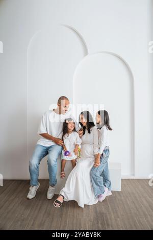 Eine Familie sitzt zusammen auf einer Couch in einem ruhigen, einladenden Raum Stockfoto