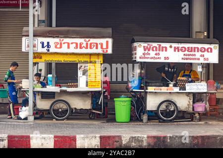 BANGKOK, THAILAND, 09. März 2024, die Street Food Kiosks, die Krabbenfleisch gebratenen Reis und knusprige Muschelpfannkuchen und Pad Thai anbieten Stockfoto