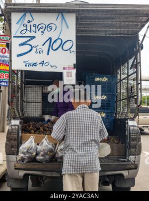 SAMUT PRAKAN, THAILAND, 1. JUNI 2024, Ein Mann kauft Mangostan in einem mobilen Geschäft auf einer Straße in der Stadt Stockfoto