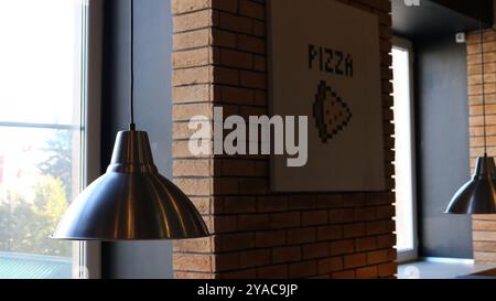 Runde Metalllampen in Cafés oder Pizzerien an Backsteinwand und Fenster, Cafeteria oder Restaurant-Innenraum als Essenshintergrund Stockfoto