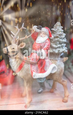 Glücklicher Weihnachtsmann, der auf einem farbenfrohen Bokeh-Hintergrund reitet. Weihnachten und Neujahrsfeier im Hintergrund. Feiertagskonzept. Kopierraum, S Stockfoto