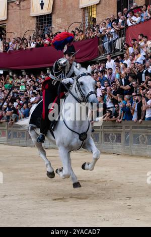 Siena, Italien – 15. August 2022: Aufführung der Carabinieri A Cavallo Mounted Police Charging mit gezogenem Säbel beim Prova-Prozess-Rennen des Palio Stockfoto