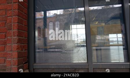 Reflexionen in einem Schaufenster, die durch einen gewalttätigen Aufprall von der Straße aus aufgerissen wurden. Stockfoto
