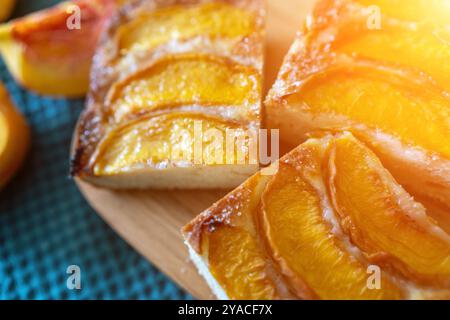 Ein Dessert aus geschnittenen Pfirsichen ist auf einem hölzernen Schneidebrett. Das Dessert ist mit Zucker bedeckt und sieht köstlich aus. Stockfoto