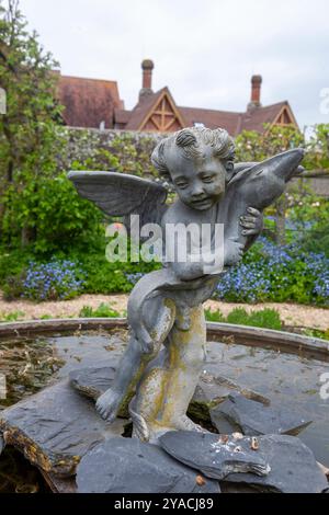 Eine Kopie von Andrea del Verrocchio's 'Putto mit Delphin', einer Skulptur aus dem 15th. Jahrhundert, in den Arundel Castle Gardens, West Sussex, Großbritannien Stockfoto