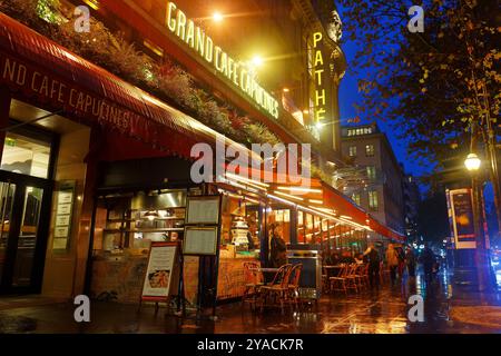 Le Grand Cafe Capucines am regnerischen Abend. Es ist die legendäre und berühmte Brasserie auf den Grands Boulevards. Inschrift in französischer Sprache auf dem Schild: Paris Stockfoto