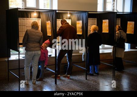 Vilnius, Litauen. Oktober 2024. Die Wähler füllen ihre Stimmzettel in einem Wahlhaus während der ersten Wahlrunde bei den Parlamentswahlen. Litauen hält die erste Runde der Parlamentswahlen zum Seimas ab. Quelle: SOPA Images Limited/Alamy Live News Stockfoto