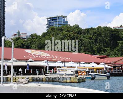 jesselton Kai in kota kinabalu malaysia. Das Gebäude ist von einem Dock mit mehreren Booten umgeben, die am Pier angedockt sind. Die Szene ist friedlich und ruhig Stockfoto