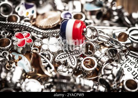 Nahaufnahme farbenfroher Charm-Perlen und Silberschmuck mit künstlerischen Designs und kreativem Ausdruck. Perfekt für Accessoires und alle, die es sehen Stockfoto