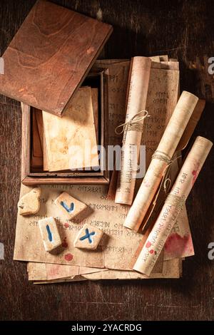 Seltsame Weissagung durch Runen-Karten und Steine mit antiker Handschrift auf Holztisch als mystischer Hintergrund Stockfoto