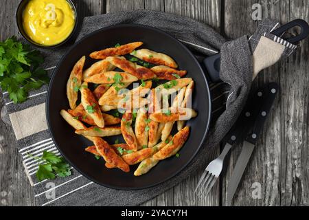 Schupfnudeln, Fingernudeln, deutsche Kartoffeldicknudeln, Knödel in einer Pfanne auf rustikalem Holztisch mit Besteck und Senf, horizontale Ansicht fr Stockfoto