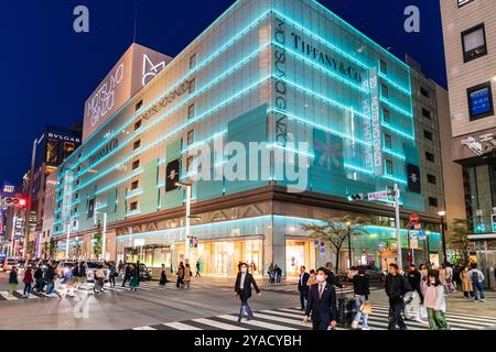 Ginza mit dem Wahrzeichen Matsuya Ginza und Tiffany Ladengebäude beleuchtet in blauen grünen, diffusen Lichtern. Im Vordergrund, Menschen auf Fußgängerübergang. Stockfoto