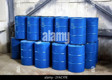 Lagerung von Erdölprodukten. Stauraum innen. Lagergebäude mit vielen blauen Fässern für Flüssigkeiten im Betonlagerbereich im Gebäude. Kunststoff und Metall Stockfoto