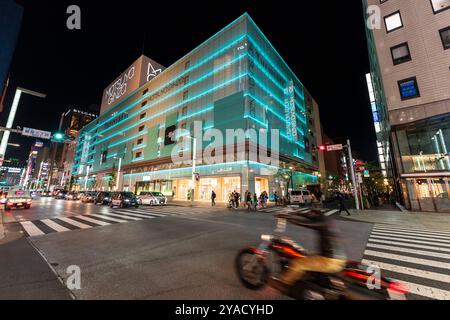 Ginza und das Geschäftsgebäude von Matsuya Ginza und Tiffany werden in blauem grünem Licht beleuchtet. Der Verkehr hielt an der Fußgängerüberquerung an, Radfahrer fuhren vorbei. Stockfoto