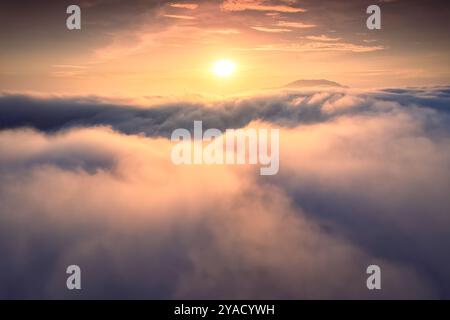 Der Sonnenaufgang aus der Vogelperspektive scheint über dem Nebelmeer am Morgen Stockfoto