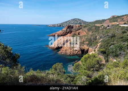 Blick auf die Corniche d’Or oder Corniche de l’Esterel wunderschöne Küstenstraße, kristallblaues Meer und Himmel kombiniert mit rötlicher Farbe des Massif de l’Est Stockfoto