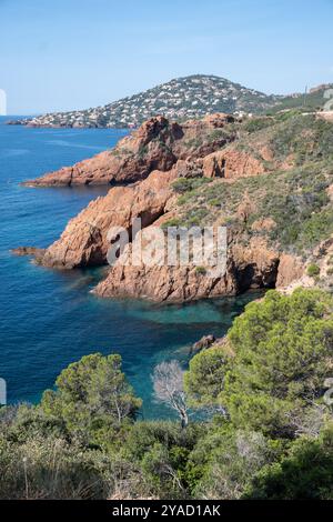 Blick auf die Corniche d’Or oder Corniche de l’Esterel wunderschöne Küstenstraße, kristallblaues Meer und Himmel kombiniert mit rötlicher Farbe des Massif de l’Est Stockfoto