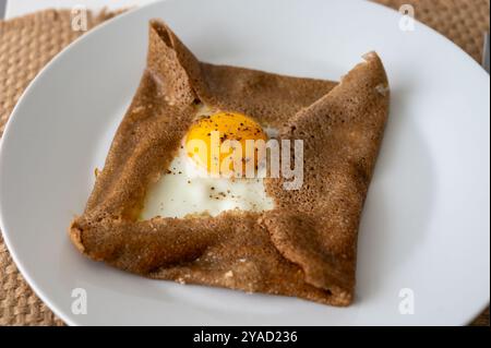 Galettes-Pfannkuchen aus der Bretagne mit Buchweizenmehl, serviert mit herzhaften Toppings, Schmelzkäse und Eiern aus nächster Nähe Stockfoto