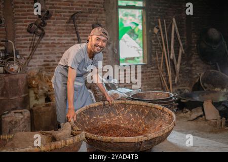 Ein erfahrener Handwerker, der sich mit der Herstellung traditioneller Körbe in der Kunsthandwerkstatt beschäftigt Stockfoto