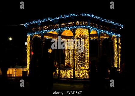 Pavillon beleuchtet mit Weihnachtslichtern neben einer Eislaufbahn bei Nacht Stockfoto