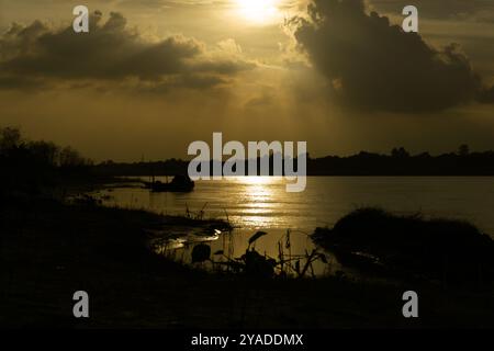 Gorai-Madhumati-Fluss von Bangladesch. Abend auf dem Fluss. Fischerboote sind am Flussufer gebunden. Der Fluss fließt unter dem Abendhimmel. Stockfoto