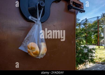 Abgestandenes Brot in einer Plastiktüte in den Müll geworfen, Essen in der Mülleimer, arme Leute essen, was sie im Müll finden Stockfoto