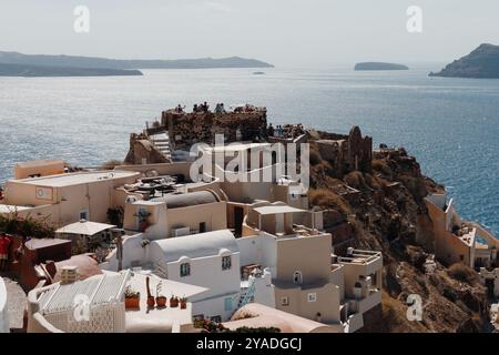 SANTORIN, GRIECHENLAND - 30. September 2024: Bunte Architektur in Oia. Wunderschöne Stadtlandschaft bei Sonnenuntergang. Berühmtes Reiseziel Stockfoto