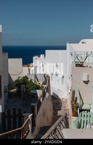 SANTORINI, GRIECHENLAND - 30. September 2024: Schöner Blick auf weiße Wohnhäuser, die durch eine enge Straße für Fußgänger getrennt sind. Stockfoto