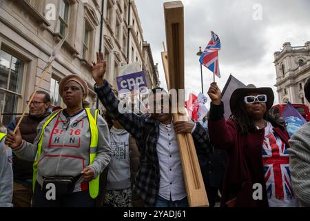 Ein Jünger Christi trägt während des marsches ein hölzernes Kreuz. Hunderte von Christen nahmen am Marsch für Jesus Teil. Die Jünger Christi hielten dann eine Kundgebung am Trafalgar Square ab, wo sie Reden, Livemusik und Gebete hörten. (Foto: James Willoughby / SOPA Images/SIPA USA) Stockfoto