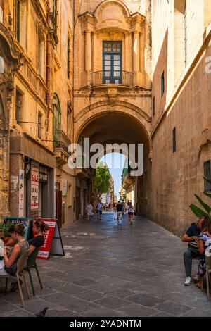 VALLETTA, MALTA - AUGUST 30 2024: Enge Straße in Valletta mit traditionellen maltesischen Gebäuden. Stockfoto