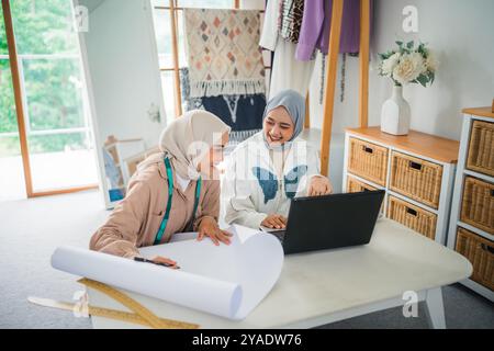 Zwei Frauen, die an einem Projekt in einer gemütlichen Home Office-Umgebung zusammenarbeiten Stockfoto