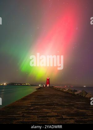 Massive aurora Borealis zeigen sich über dem Poolbeg Lighthouse von einem geomagnetischen G4-Sturm im Oktober 2024 Stockfoto