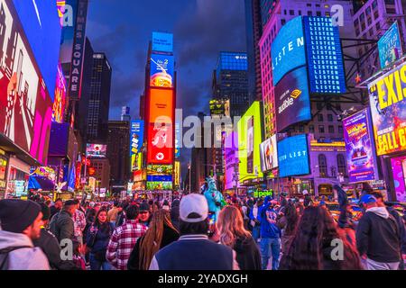 Times Square bei Nacht mit hellen digitalen Plakaten, Touristenmassen und pulsierenden Lichtern in New York. Stockfoto