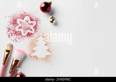 Weihnachtsdekorationen aus Puder und Rouge, Kugeln und Make-up-Pinsel auf weißem Hintergrund, flach gelegt. Leerzeichen für Text Stockfoto