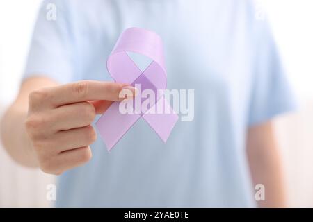 Frau mit violettem Band auf hellem Hintergrund, Nahaufnahme. Alzheimer-Krankheit, Epilepsie und Pankreaskarzinom-Bewusstsein Stockfoto