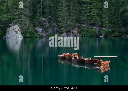 Holzboote, die auf smaragdgrünen Gewässern im Herzen des Pragser Wildsees schwimmen Stockfoto