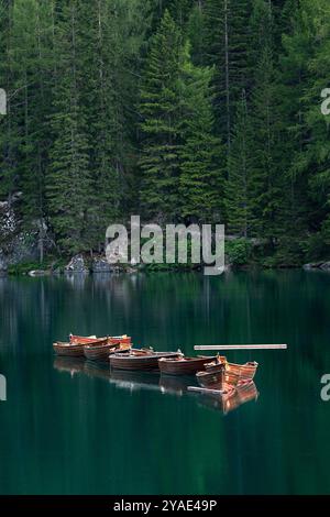 Holzboote, die auf smaragdgrünen Gewässern im Herzen des Pragser Wildsees schwimmen Stockfoto