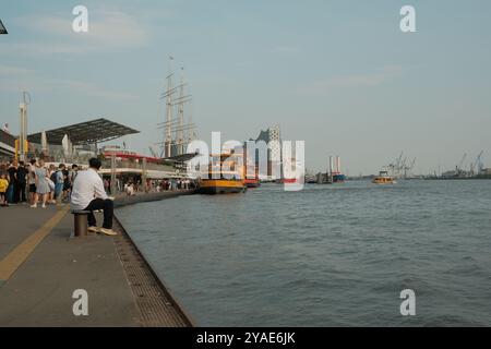 Der Landungsbrücken-Hafen am Elbufer mit der Elbphilharmonie im Hintergrund der Stadt Hamburg. Stockfoto