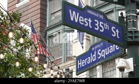 Kreuzung New York City, Straßenschild an der Kreuzung Manhattan Broadway Street. NYC Midtown District Architektur, Herald Square Park, 6 Sixth Avenue, Vereinigte Staaten. Amerikanische Flagge. Wegweiser mit Pfeil. Stockfoto