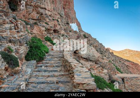 Die Steintreppen, die zum Kloster Hozoviotissa führen, das im Jahr 1017 erbaut wurde und auf der Klippenseite, oberhalb der Ägäis, in Amorgos, Kykladen, Griechenland thront Stockfoto