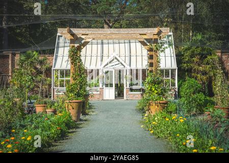 Ein schöner, formeller, ummauerter Garten mit viktorianischem Gewächshaus und Gemüseflecken in einem englischen Landgarten Stockfoto