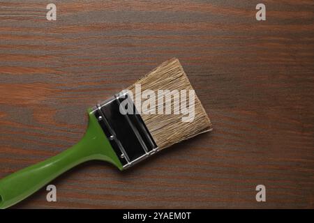 Auftragen von Walnussholz-Beize. Bürste auf Holzoberfläche, Draufsicht Stockfoto