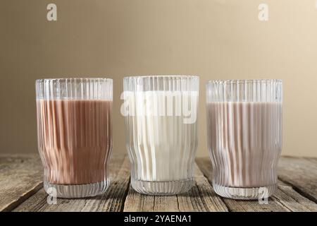 Verschiedene leckere Proteincocktails in Gläsern auf Holztisch Stockfoto