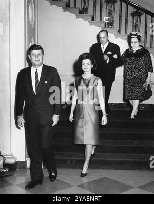 US-Präsident John F. Kennedy und First Lady Jacqueline Kennedy kommen in der Eingangshalle zum diplomatischen Empfang an, Botschafter von Nicaragua und Dekan des Diplomatischen Korps, Dr. Guillermo Sevilla-Sacasa, und Lillian Somoza de Sevilla-Sacasa im Hintergrund, Weißes Haus, Washington, D.C., USA, Abbie Rowe, Fotos Des Weißen Hauses, 21. Februar 1963 Stockfoto