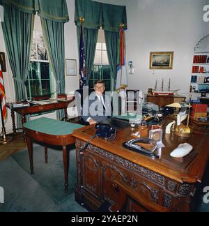 US-Präsident John F. Kennedy sitzt an seinem Schreibtisch (HMS Resolute Desk), Oval Office, Weißes Haus, Washington, D.C. USA, Cecil Stoughton, Fotos des Weißen Hauses, 1962 Stockfoto