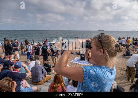 Barcelona, Spanien. Oktober 2024. Eine Frau folgt den Segelrennen mit einem Fernglas vom Strand aus. Der zweite Tag des America's Cup Finales fand heute in Barcelona statt. Die Fans der beiden Teams Emirates und Ineos konnten das Rennen von den Stränden und Bars von Barceloneta aus verfolgen. (Foto: Paco Freire/SOPA Images/SIPA USA) Credit: SIPA USA/Alamy Live News Stockfoto