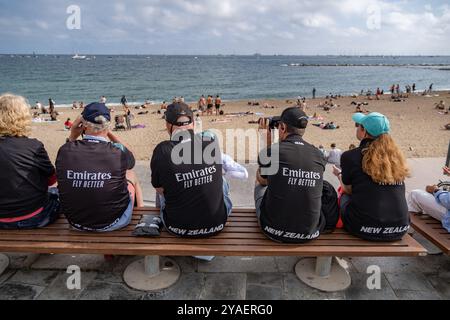 Barcelona, Spanien. Oktober 2024. Fans des Emirates Team New Zealand sehen die Segelrennen mit einem Fernglas vom Strand aus. Der zweite Tag des America's Cup Finales fand heute in Barcelona statt. Die Fans der beiden Teams Emirates und Ineos konnten das Rennen von den Stränden und Bars von Barceloneta aus verfolgen. (Foto: Paco Freire/SOPA Images/SIPA USA) Credit: SIPA USA/Alamy Live News Stockfoto