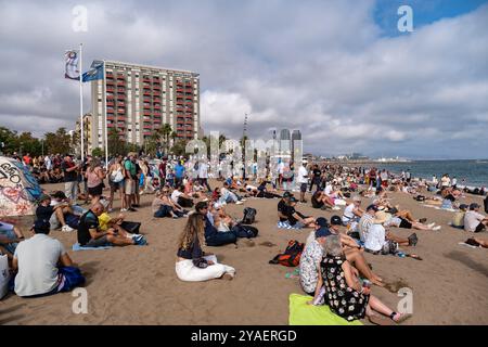 Barcelona, Spanien. Oktober 2024. Eine Menschenmenge am Strand verfolgt die America's Cup Segelrennen. Der zweite Tag des America's Cup Finales fand heute in Barcelona statt. Die Fans der beiden Teams Emirates und Ineos konnten das Rennen von den Stränden und Bars von Barceloneta aus verfolgen. (Foto: Paco Freire/SOPA Images/SIPA USA) Credit: SIPA USA/Alamy Live News Stockfoto
